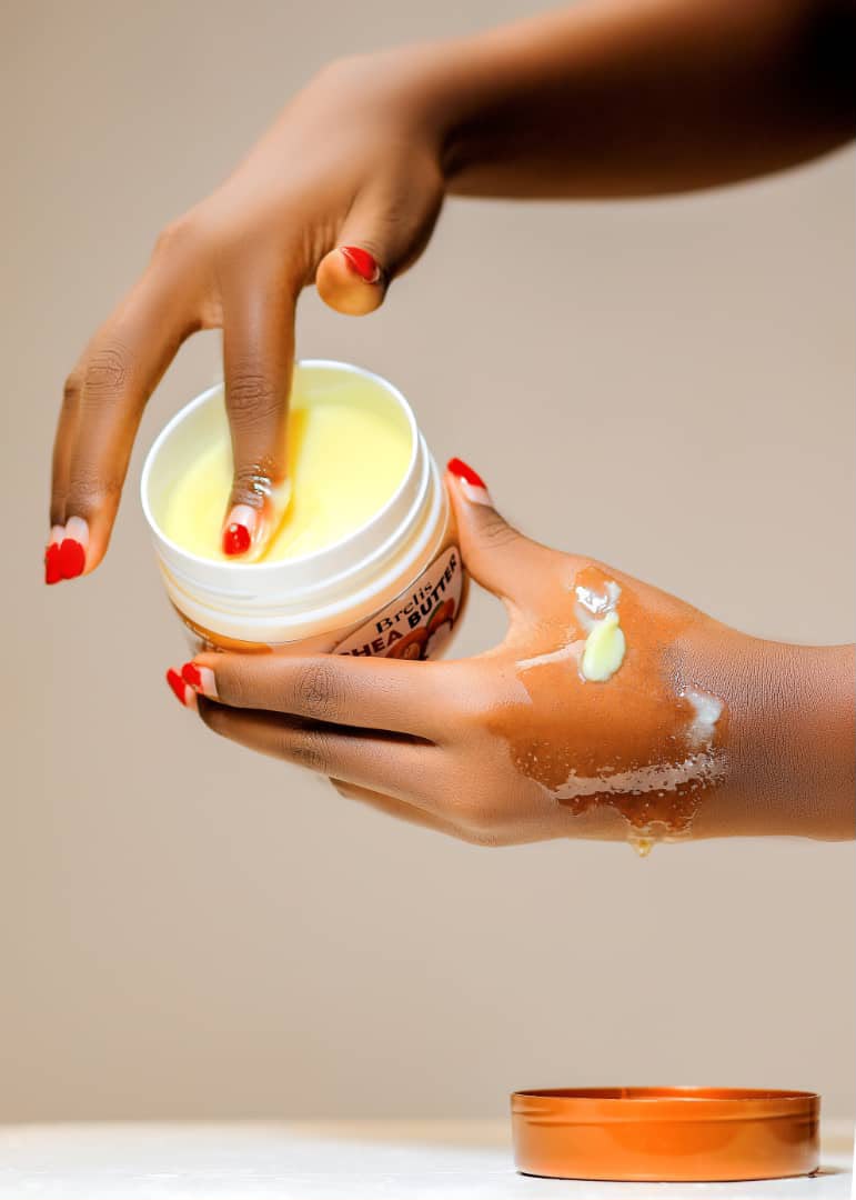 Brelis shea butter being applied to skin from an open jar